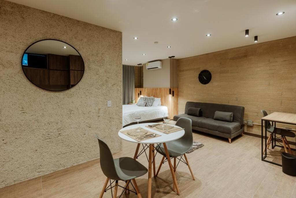 a bedroom with a bed and a couch and a table at Cozy Loft in Class 48 in Sabaneta