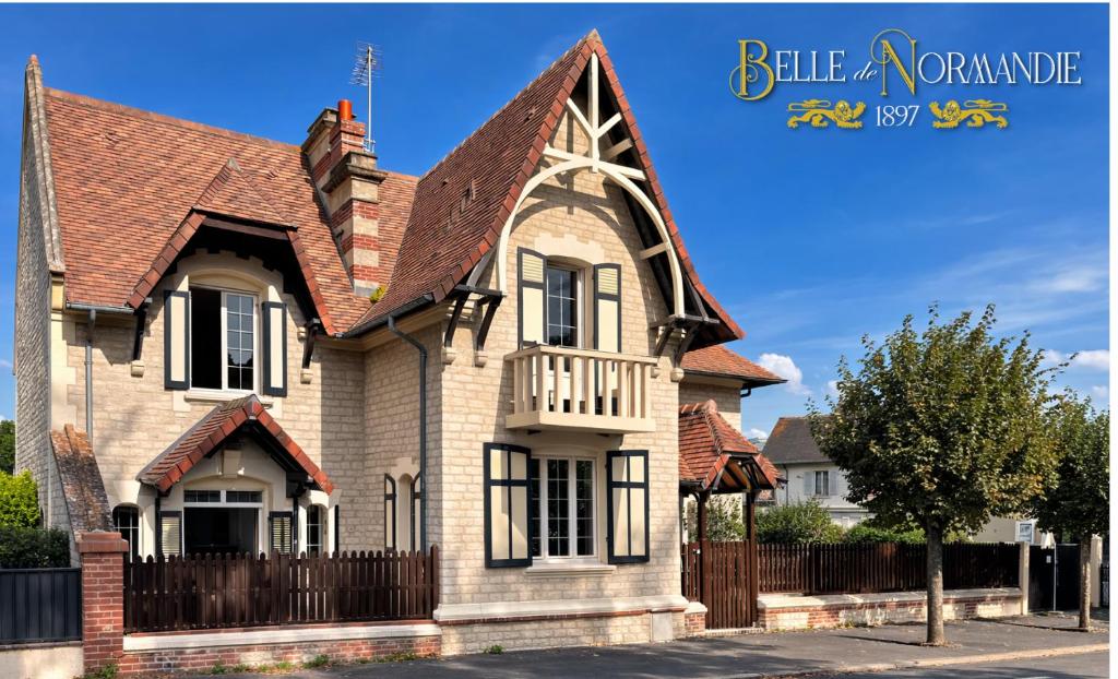 a house with a brown roof and a fence at Belle de Normandie- Villa Balnéaire d'Exception - Plage au bout de la rue in Ouistreham
