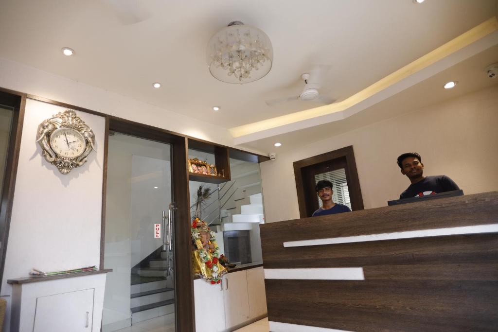 two men standing at the counter of a restaurant at Hotel Center Point in Bhubaneshwar