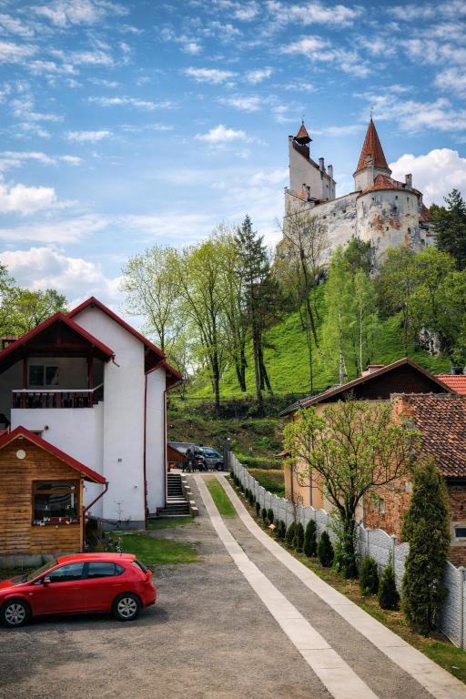 a red car parked in front of a castle at Casa Krista in Bran