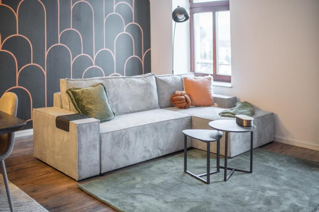 a living room with a couch and two tables at Ruhiges City-Wohnapartment - 5 min zum Markplatz in Annaberg-Buchholz