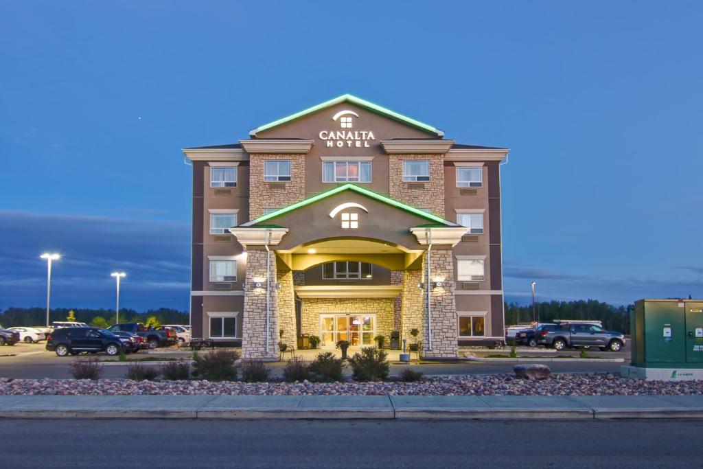 a hotel building with a sign on the front of it at Canalta Hotel Lac La Biche in Lac La Biche