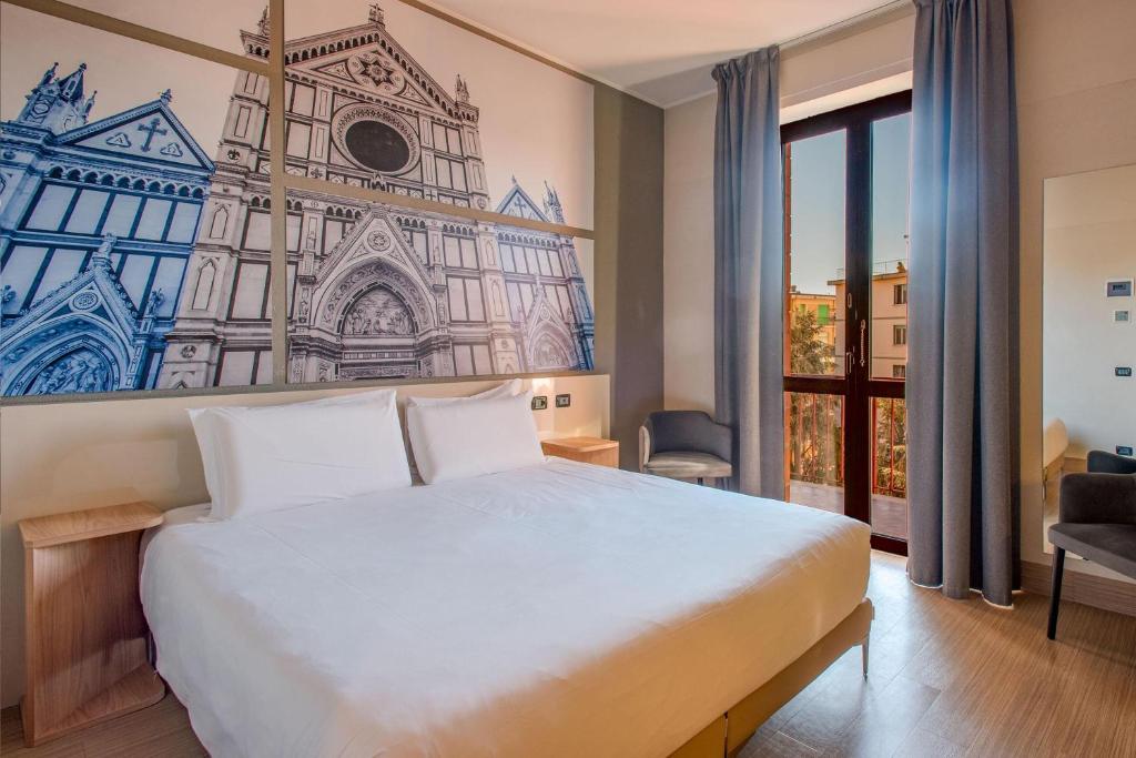 a bedroom with a large white bed with a painting on the wall at B&B Hotel Firenze Nuovo Palazzo Di Giustizia in Florence