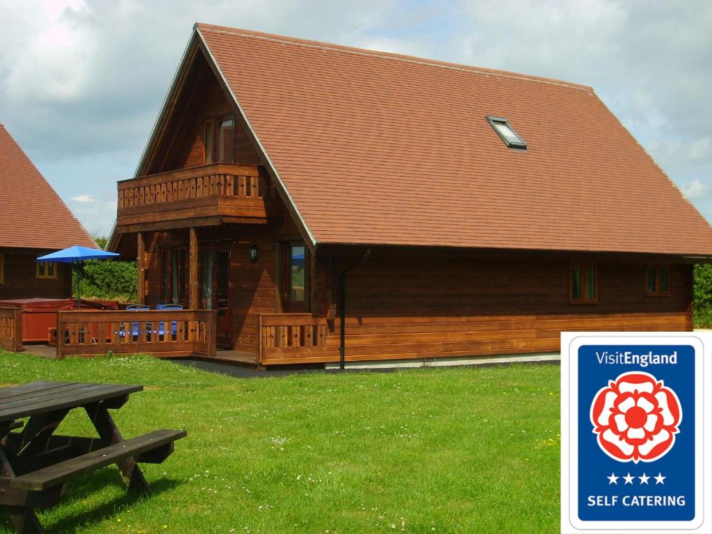 a log cabin with a picnic table in front of it at Melbury Chalet in West Stour
