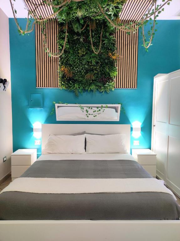 a bedroom with a bed with a blue wall at Tropical Holiday House in Catania