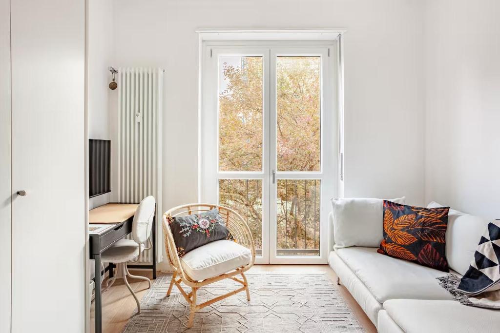 a living room with a couch and a desk and a window at Suite and Home between Milano, Malpensa e Como Lake in Saronno