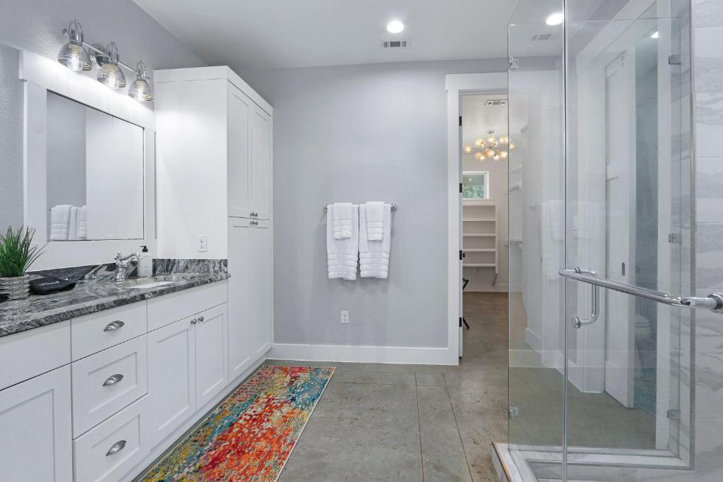 a white bathroom with a shower and a sink at Gatlin Getaway in Dripping Springs