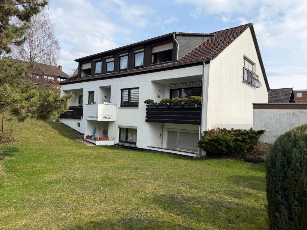 a white house with black windows and a yard at Apartment Alex in Hildesheim