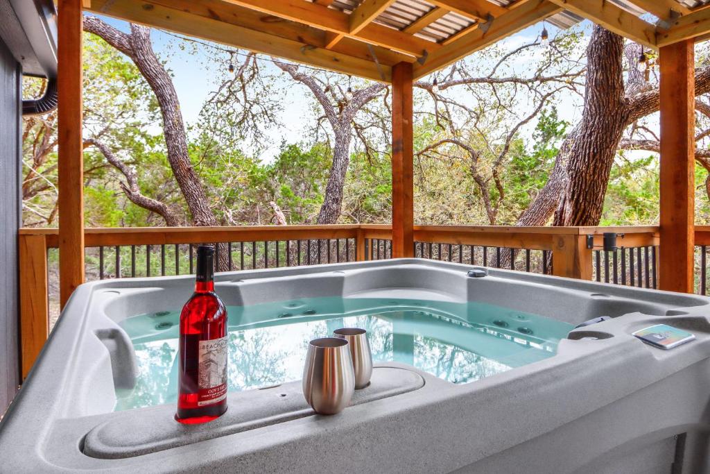 a bath tub with a bottle of wine sitting in it at Good Day Treehouse in Wimberley