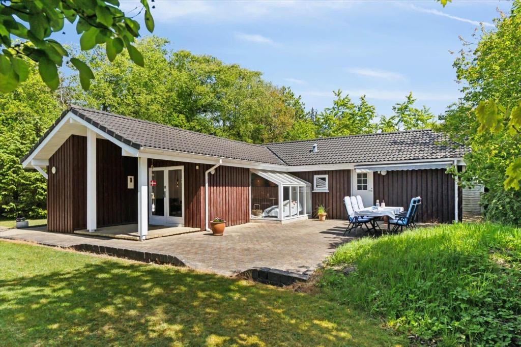a cottage with a patio and a table at BL1163-Blokhus-Raappenmark-2 in Blokhus