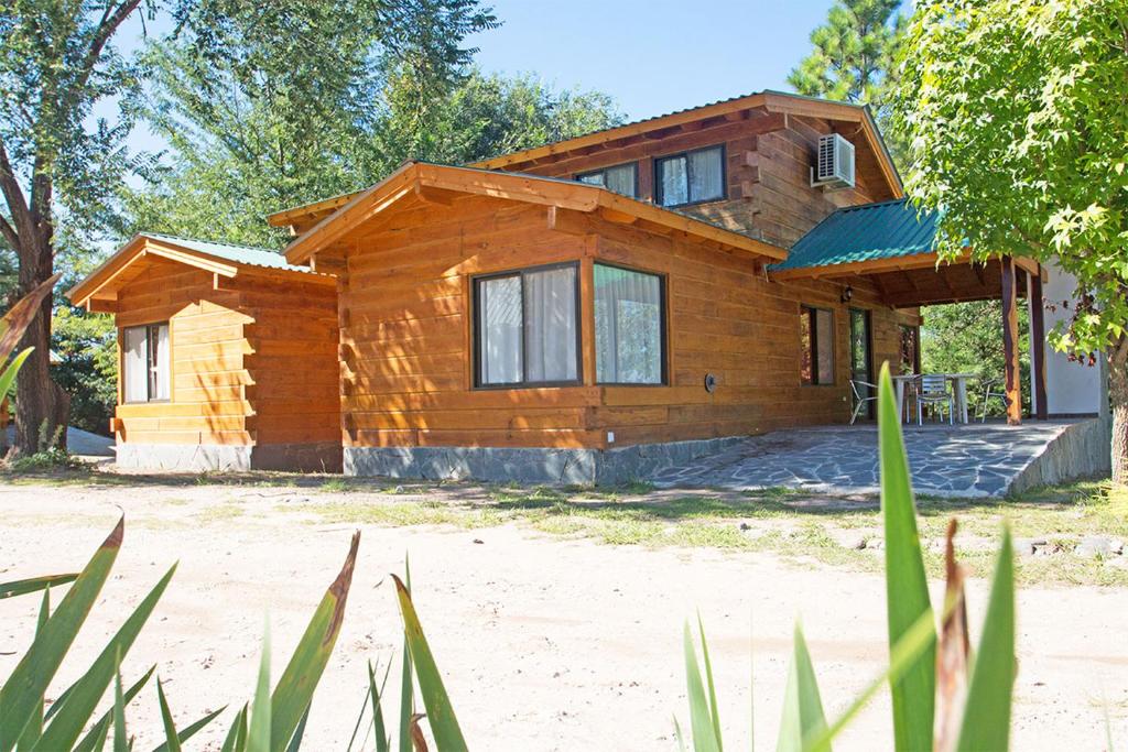 a log home on a beach with trees at casas del milagro in Villa General Belgrano