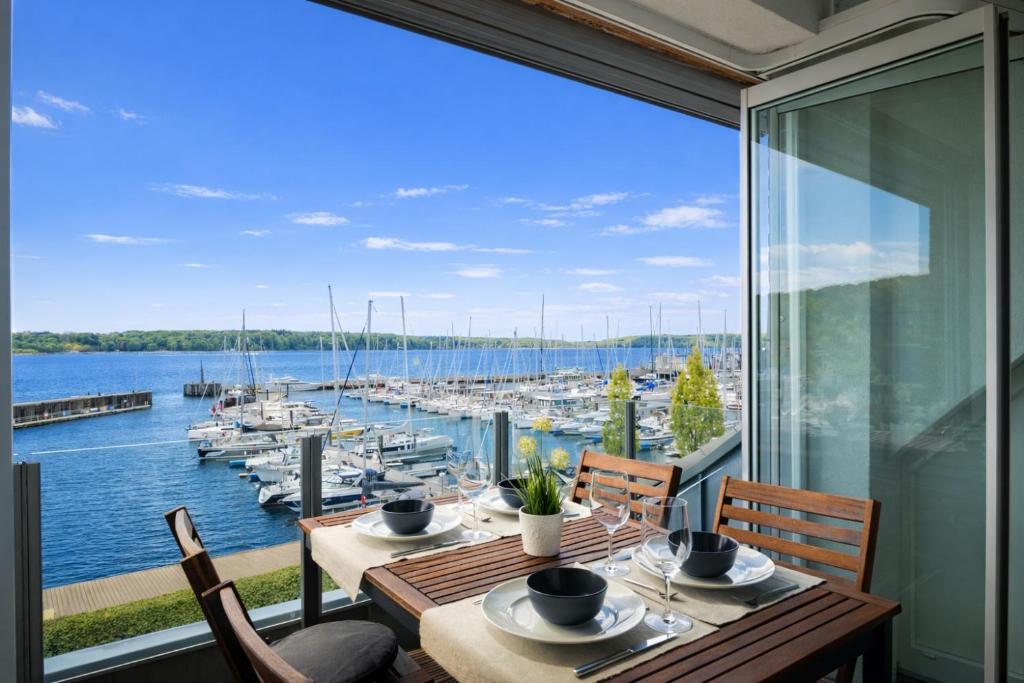 a dining room with a view of a marina at fewo1846 - Baltic Lodge - komfortable Maisonettewohnung mit 3 Schlafzimmern, Balkon und Blick auf die Marina Sonwik in Flensburg