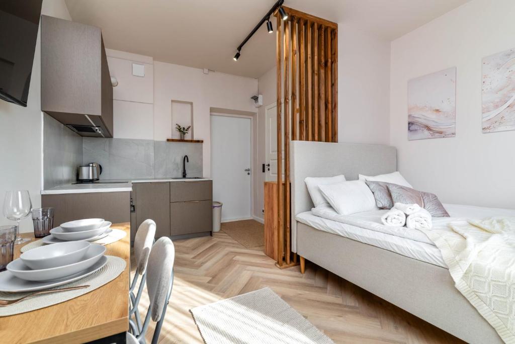 a room with a bed and a table and a kitchen at Jakobsoni 15 Apartmendid in Viljandi