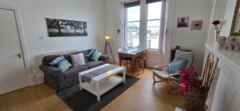 a living room with a couch and a table at Grindlay Street Residence, 2 Bedroom, 2 Bathroom apartment close to Castle in Edinburgh