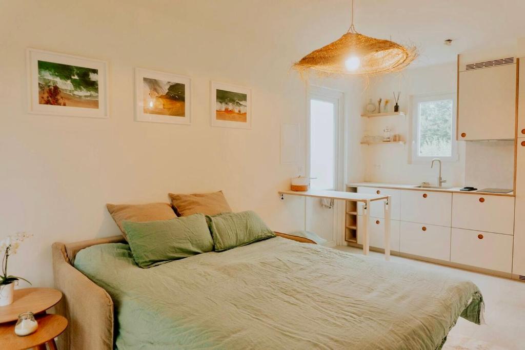 a bedroom with a bed and a small kitchen at Palmito in Bidart
