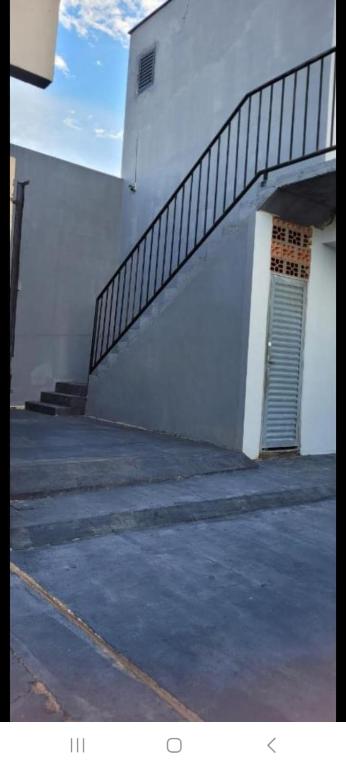 a stairway next to a white building with a door at Flat in Rio Verde