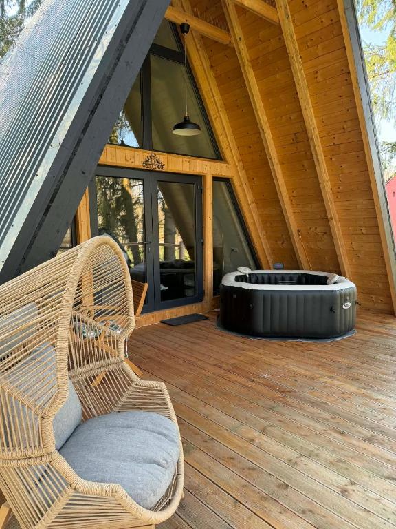 a wicker chair sitting on the deck of a cabin at Patak Kuckó cabin ház in Szőce