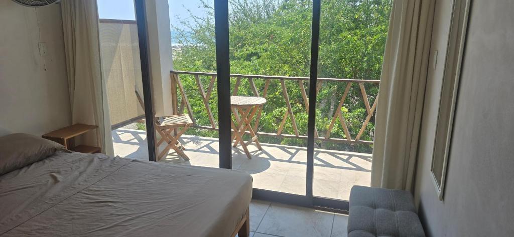 a bedroom with a bed and a view of a balcony at Casa Laud Cuarto Guamuchil in Guayabas