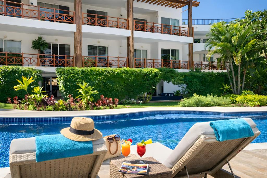 ein Resort mit Swimmingpool und einer Cocktailbar. in der Unterkunft Luxury Duplex 2BR Pool & Garden View Quiet 30m from 5th Ave with Gym & Parking in Playa del Carmen