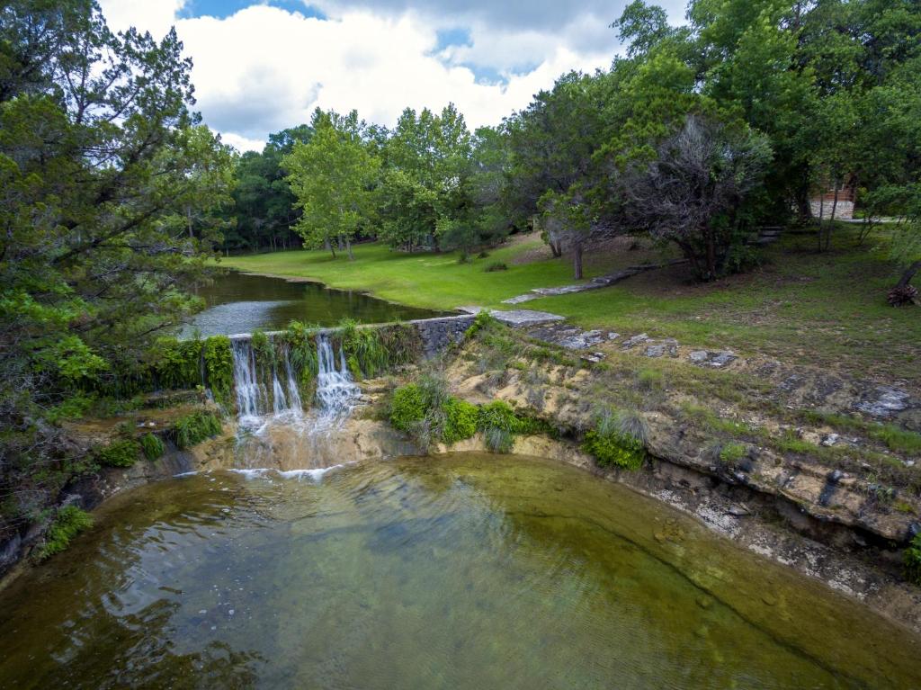 an aerial view of a waterfall in a park at Falls Log Home in Wimberley