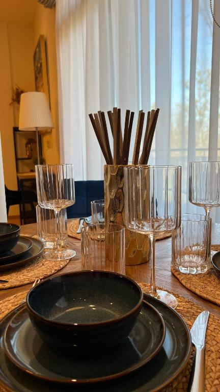 a table with a black plate and glasses on it at DO Apartments in Druskininkai