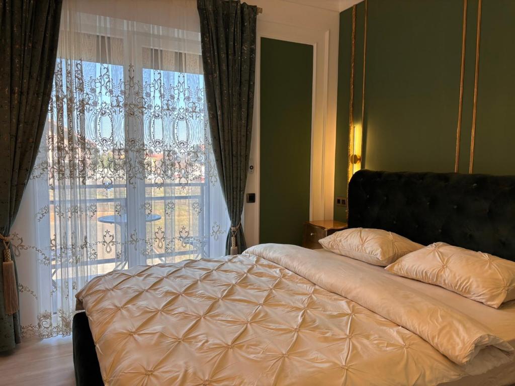 a bed in a bedroom with a large window at Vert Unique Luxury Experience in Băile Felix in Baile Felix