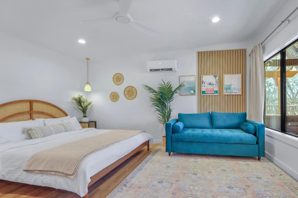 a bedroom with a bed and a blue couch at Dew Drop Inn in Wimberley