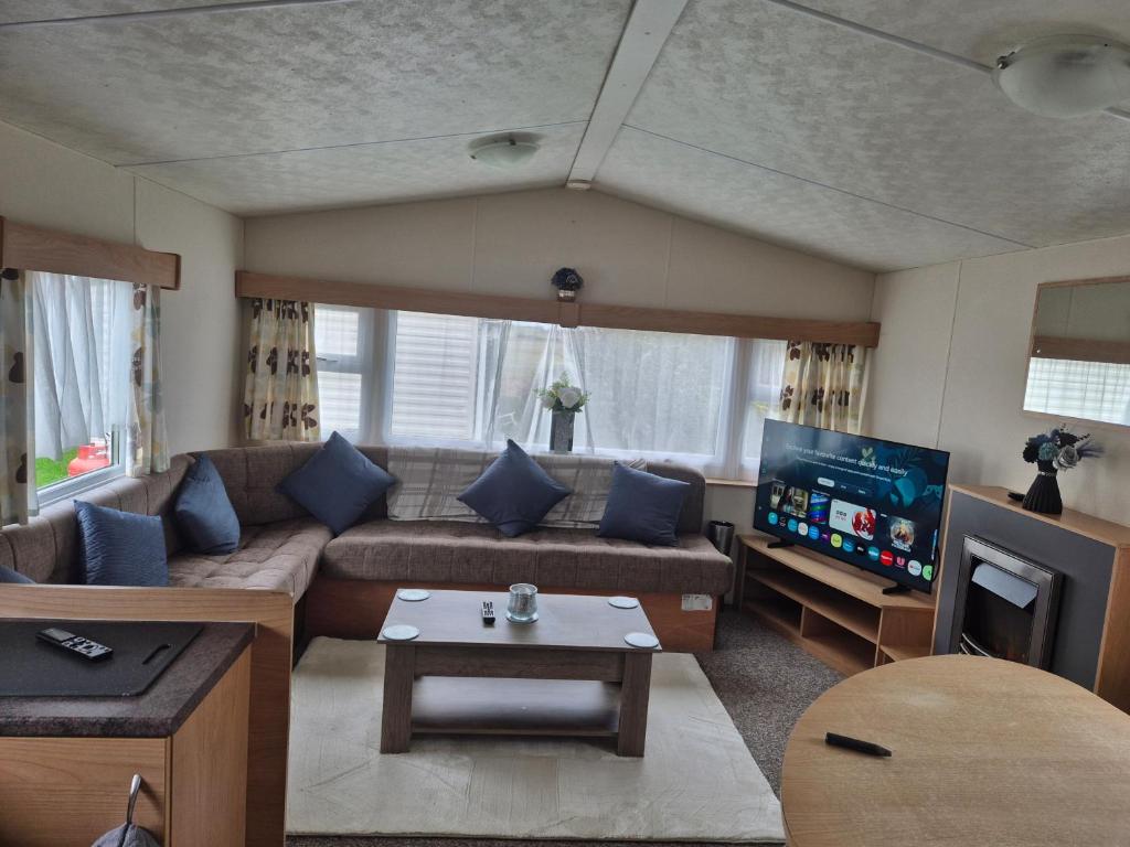 a living room with a couch and a tv at Blanco's by the sea in Saint Osyth