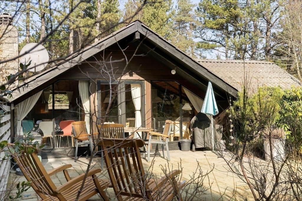 a house with a patio with chairs and an umbrella at 2614-Romo-Stormengevej-18 in Høm