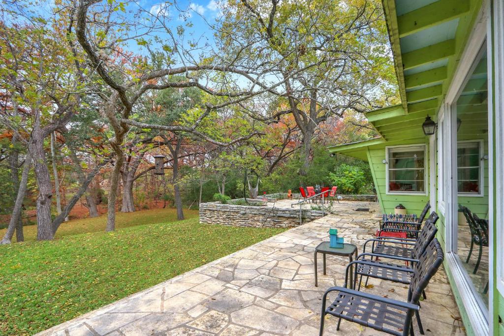 a green house with two benches on a patio at Cypress Moon in Wimberley