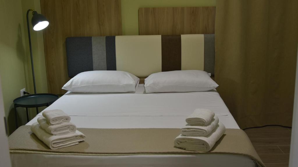 a bed with three towels on the side of it at Le Dune del Gargano in Zapponeta