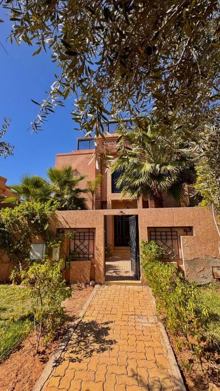 a house with a brick walkway in front of it at Villa de prestige à Marrakech in Marrakesh