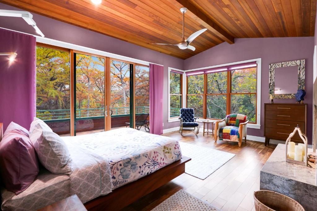 a bedroom with a bed and a room with windows at Cypress Star in Wimberley