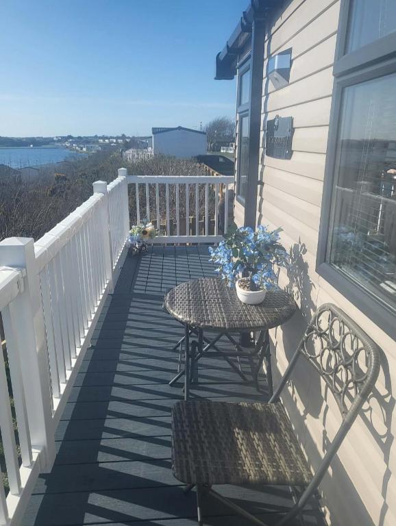 a patio with a table and chairs on a balcony at The Bluebell in Haverigg