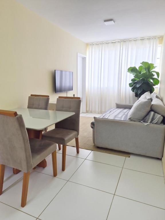 a living room with a table and a couch at AP Climatizado aconchego com Mercado em frente in Vitória da Conquista