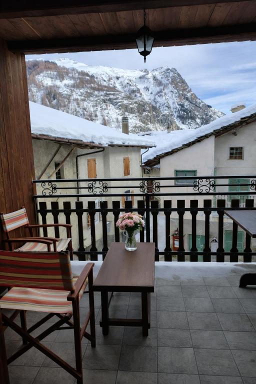 a balcony with a table and chairs and a snowy mountain at Appartamento Alta Valle Maira - Midia in Villaro