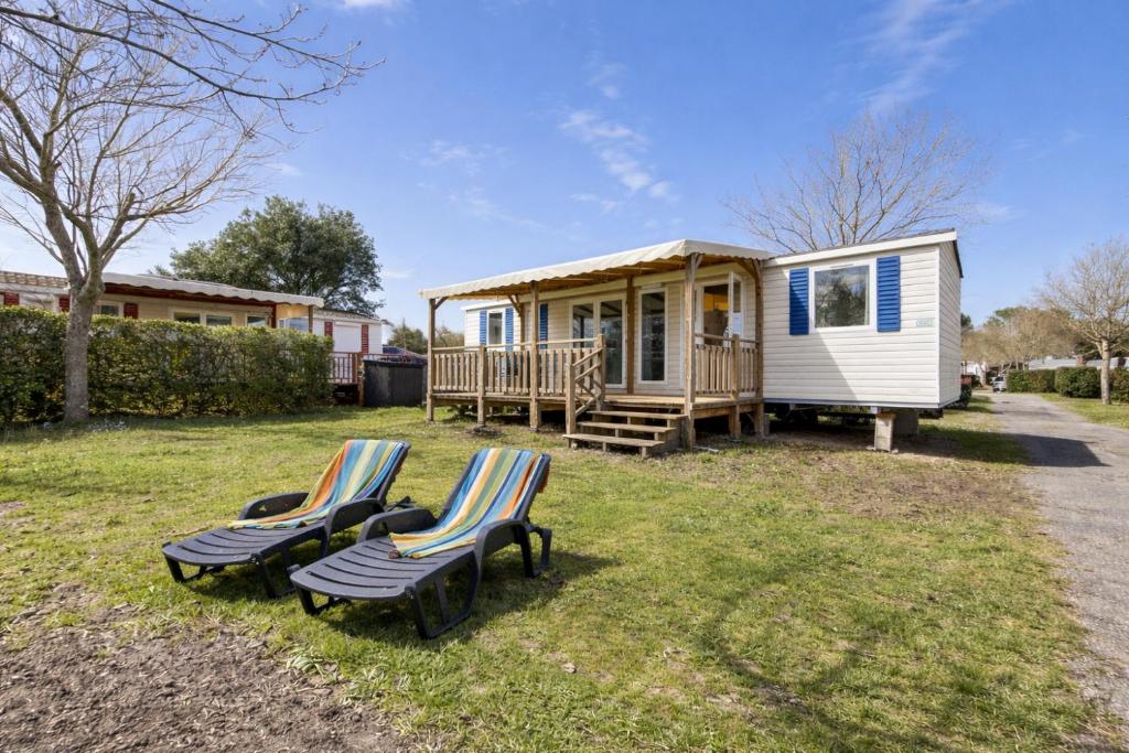 a couple of chairs sitting in front of a tiny house at Mobilhome L'Instant Vacances - La Plage in Mimizan-Plage