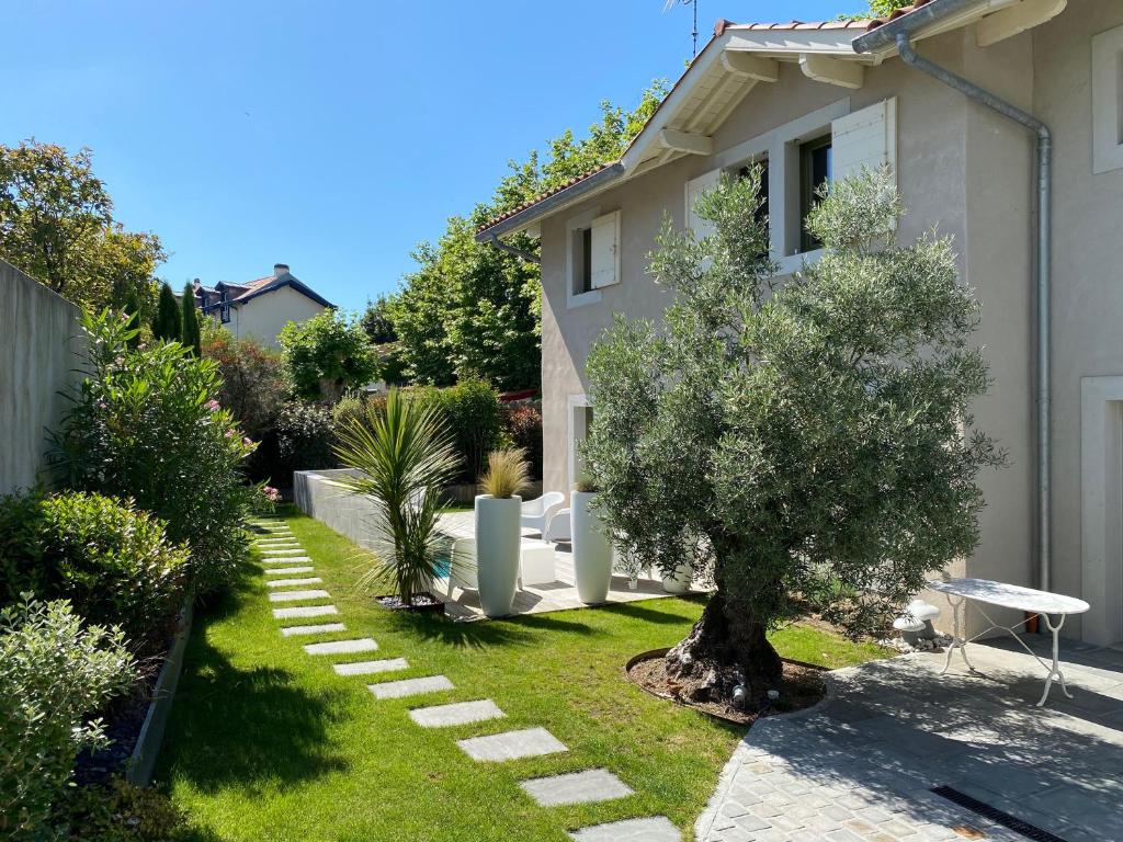 a garden with a tree and a house at Chambre d'Hôtes Arima in Biarritz