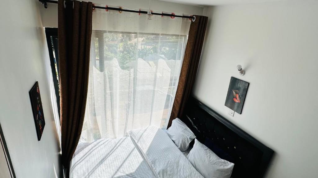 a bedroom with a window with a bed at SympaHome in Kiambu