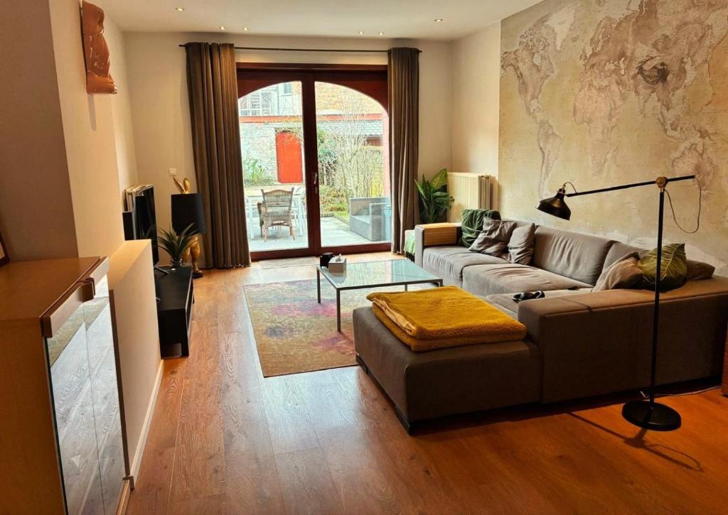 a living room with a couch and a table at Spacious Design Home with Garden near Centre in Bruges