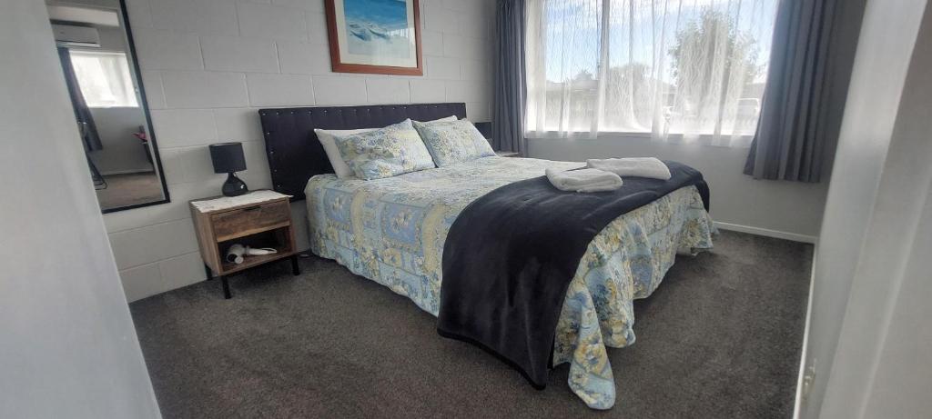 a small bedroom with a bed and a window at Fantastic Two Bedroom Unit in Whakatane