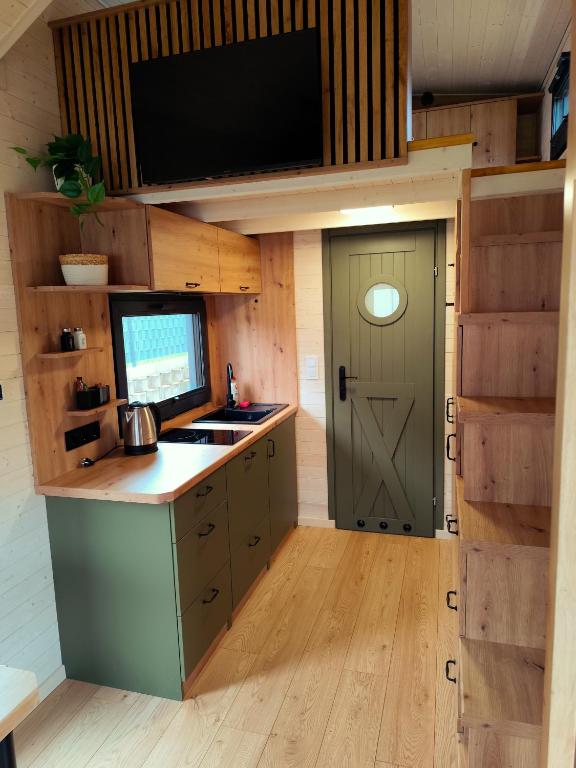 a kitchen with a sink and a door with a tv at Dauny House - Dein Tiny House Erlebnis in der Vulkaneifel in Daun