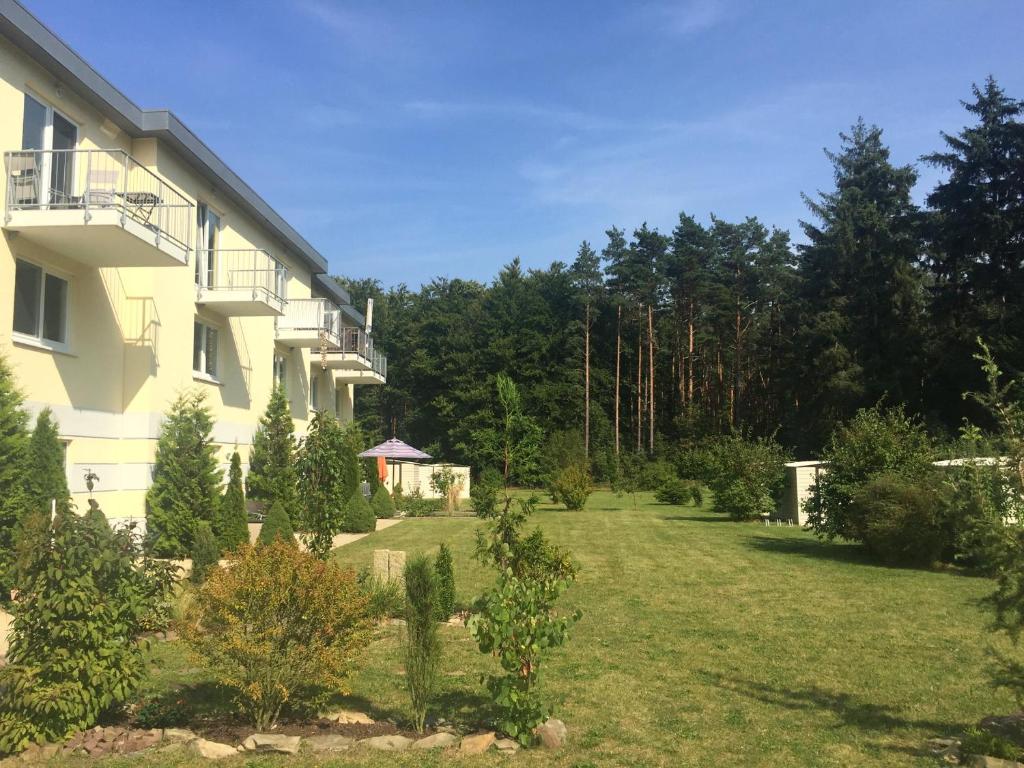 een tuin naast een groot gebouw met bomen bij Ruhige Ferienwohnung in Graal Müritz (EW) in Graal-Müritz