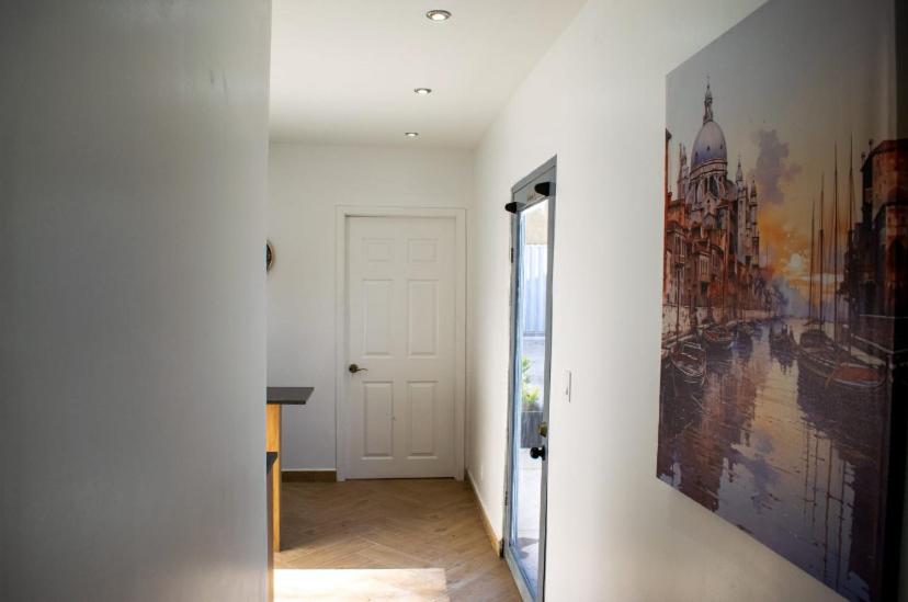 a hallway with a door and a painting on the wall at Hotel Royal a 5 min del consulado EE UU in Heroica Nogales