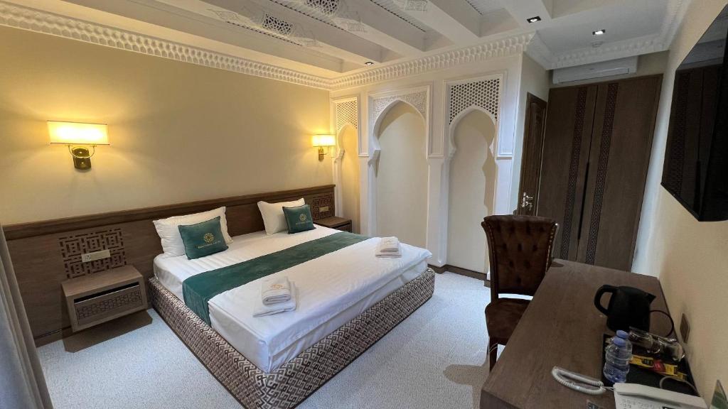 a hotel room with a bed and a table and a desk at Shams Boutique Hotel in Bukhara