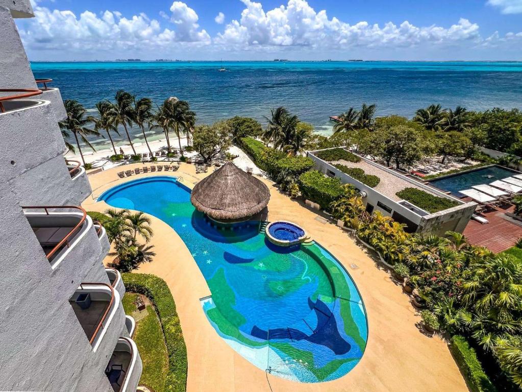 an aerial view of a resort swimming pool and the ocean at Isla Condo Puerta al Mar 403 at Sac Bajo in Isla Mujeres
