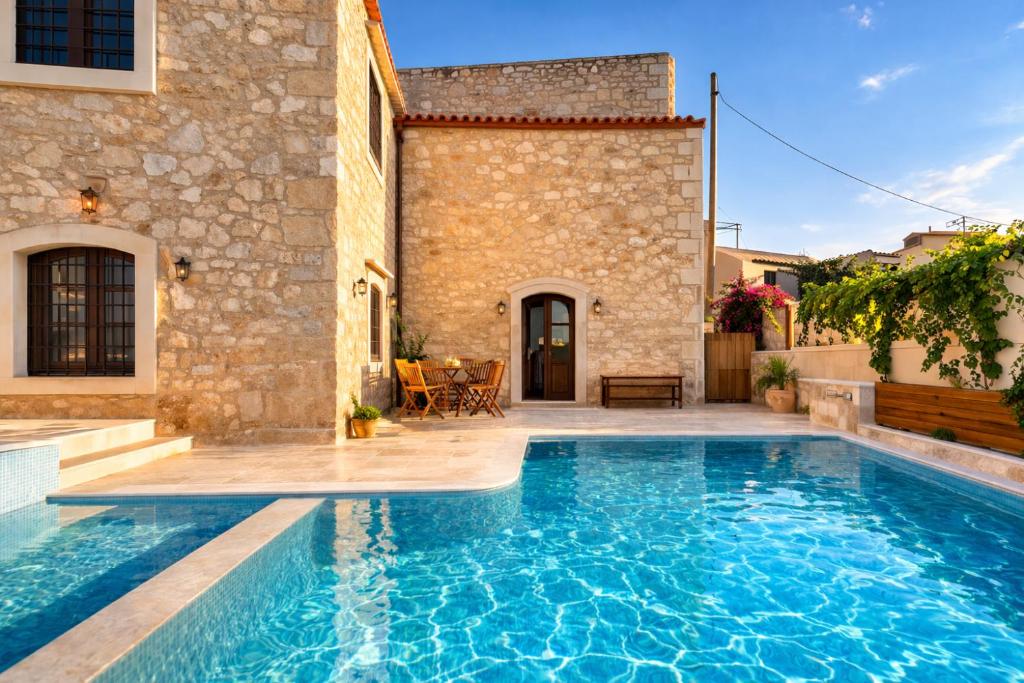 a pool in the backyard of a house with a building at Villa Kaladare - Private Pool & Quiet Relaxing Stay in Kalandares