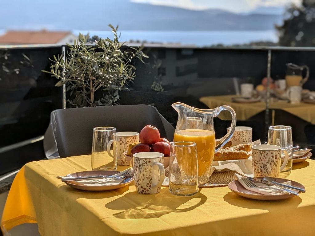 a table with a pitcher of juice and fruit on it at Seaview Residence Krk 2 Bedrooms 2 Bathrooms Free Parking in Krk