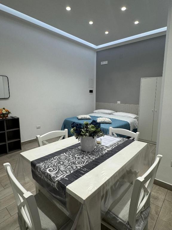 ein Zimmer mit zwei Betten und einem Tisch mit Blumen darauf in der Unterkunft Aleila in Bacoli