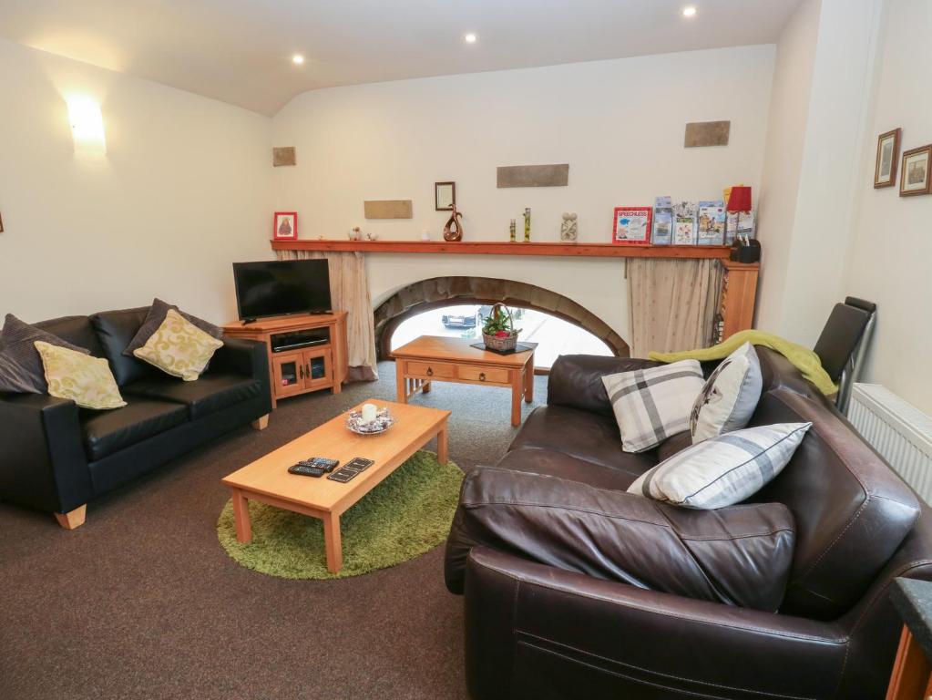 a living room with two couches and a fireplace at Green Route Apartment in Todmorden